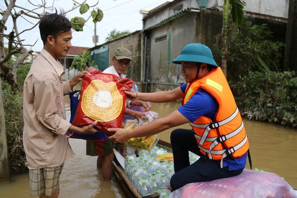 Bà con vùng lũ sẻ chia với nhau quà bạn đọc báo Tuổi Trẻ