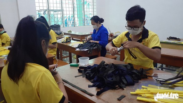 Anh đạp xe chở em xung phong đi làm mặt nạ chống giọt bắn phòng COVID-19